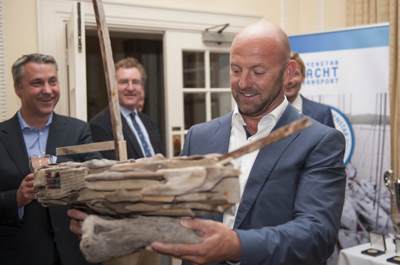 Ian Walker holding the driftwood boat prize for Monohull Line Honours