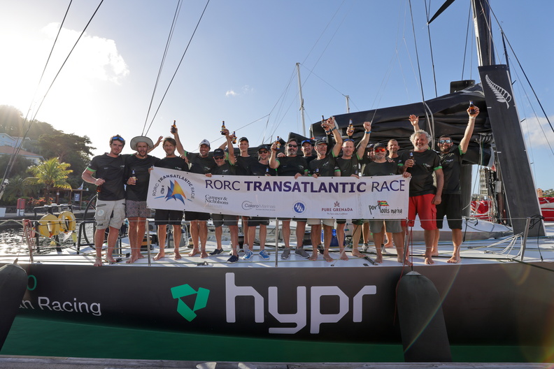 Hypr crew gather on deck with the official race banner