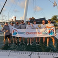 The winning crew of Argo pose with the race banner, new record-holders