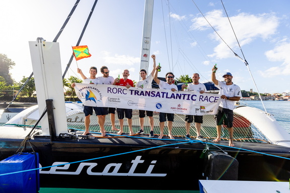 Maserati's crew gather on board with the race banner