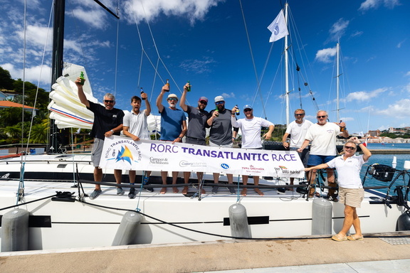 The crew of the Lombard 46 Pata Negra celebrate with their race banner