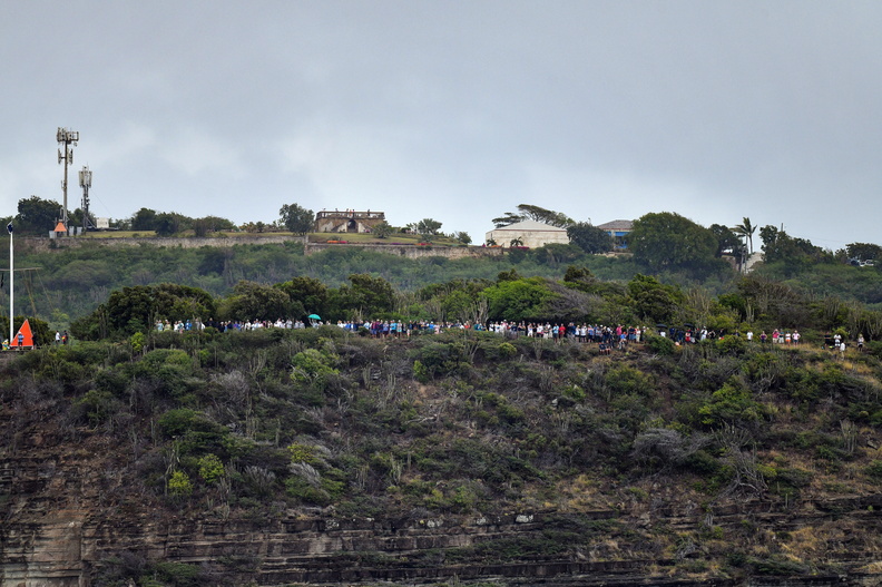 Despite overcast weather a crowd gathers to watch the start from the clifftop